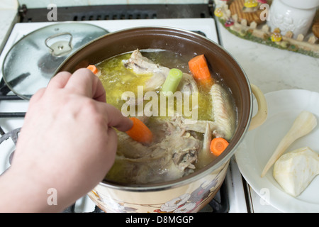 Preparation of broth with chicken, turkey, beef, and vegetables. Polish cuisine. Stock Photo