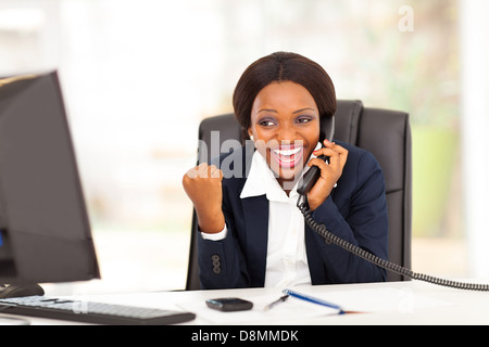 young African American businesswoman receiving excited news in office Stock Photo