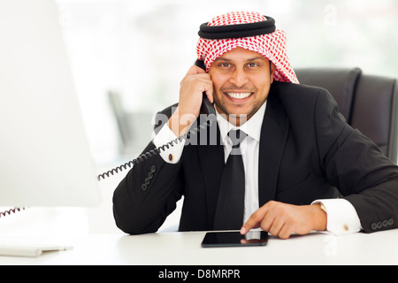 happy arabian corporate worker talking on the landline phone Stock Photo