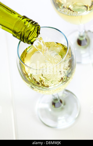 Glass of White Wine Being Poured - white wine being poured into a glass, looking down. Semi sparkling moscato, Australian wine. Stock Photo