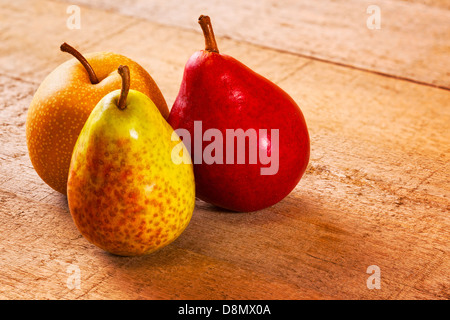 Pears on a Rustic Wood Surface - three different pears on a rustic wooden plank surface... Stock Photo