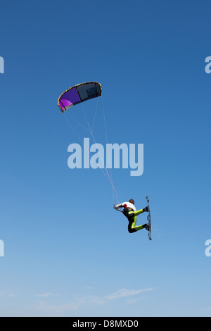 Kitesurfer flying high up in the air against a blue sky. Cannes, French Riviera, Alpes-Maritimes, France. Stock Photo
