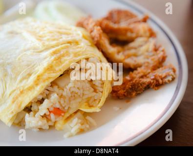 Fried rice wrapped by omelet on the white dish, Thai food Stock Photo