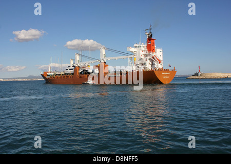 Dutch registered cargo ship “SNOEKGRACHT” (168 mtrs) departing port with a deck cargo of boats / yachts - with pilot boat escort Stock Photo