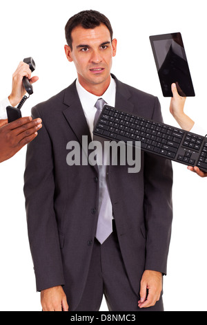 tired male office worker with multiple gadgets around him Stock Photo