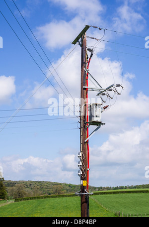 overhead Electricity cables carried on a pole in a rural area. Stock Photo