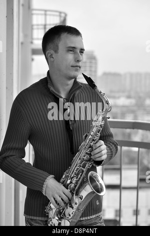 handsome young man playing on saxophone outdoor Stock Photo