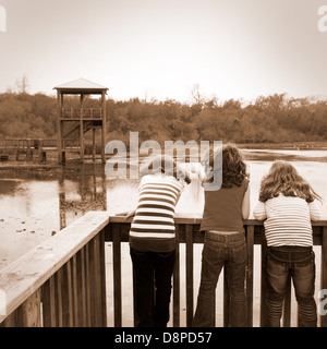 kid children girls looking and pointing at park lake in Texas rear view Stock Photo