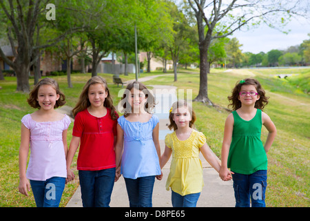 Children group of sisters girls and friends walking happy in the park outdoor Stock Photo
