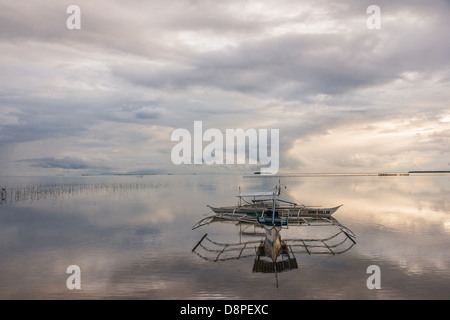 Two bangkas - a traditional Filipino fishing boats - safely moored for the night Stock Photo