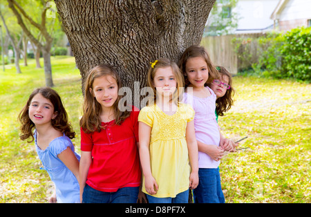 Children group friend girls friends playing on tree trunk at the park outdoor Stock Photo