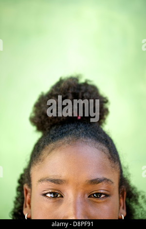 Cropped view of pretty happy young african girl looking at camera and smiling against green background. Copy space Stock Photo