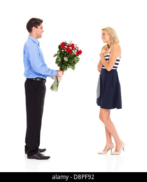 A young man giving bunch of red roses to his girlfriend while closing ...