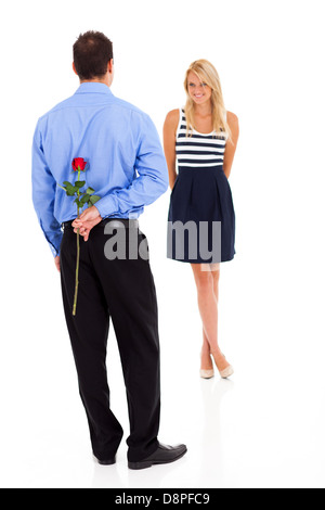 romantic young man hiding rose behind his back Stock Photo
