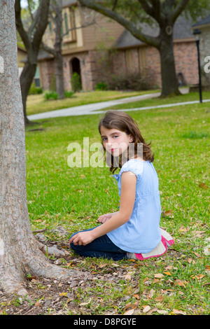 beautiful kid girl smiling sitting on park lawn relaxed outdoor Stock Photo