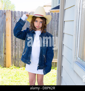 Little kid girl pretending to be a cowboy with father hat and jacket Stock Photo