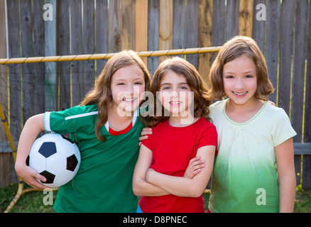 three sister girls friends soccer football winner players on the backyard Stock Photo