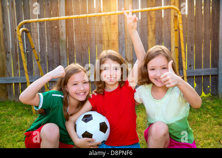 three sister girls friends soccer football winner players on the backyard Stock Photo