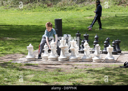 Young boy playing chess by himself at Margam country park, Wales, UK. Stock Photo