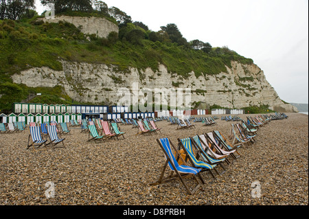 Wet summer day on Beer Beach in Devon with unused deck chairs Stock Photo