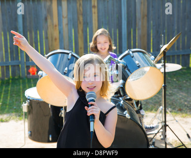 Blond kid singer girl singing playing live band in backyard concert with friends Stock Photo