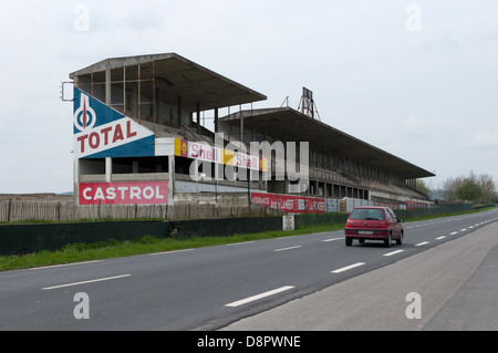 A (motion blurred) car passing the remains of part of the Reims-Gueux Racing Circuit in northern France. Stock Photo