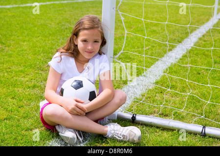 Soccer football kid girl relaxed on grass lawn with ball Stock Photo