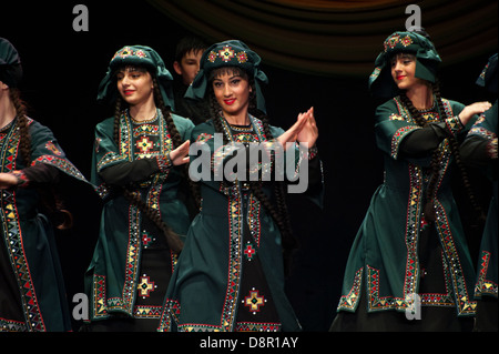 Georgian children dressed with traditional costumes dancing a folklore dance show on stage. Stock Photo