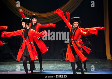 Georgian children dressed with traditional costumes dancing a folklore dance show on stage. Stock Photo