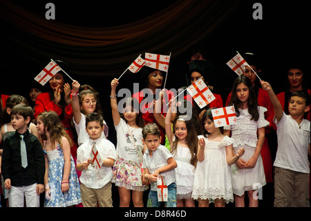 Georgian children dressed with traditional costumes dancing a folklore dance show on stage. Stock Photo