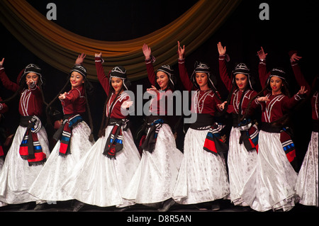 Georgian children dressed with traditional costumes dancing a folklore dance show on stage. Stock Photo