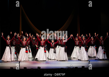 Georgian children dressed with traditional costumes dancing a folklore dance show on stage. Stock Photo