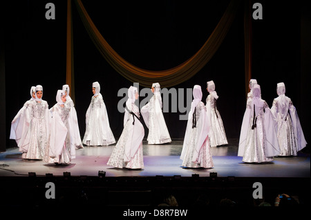 Georgian children dressed with traditional costumes dancing a folklore dance show on stage. Stock Photo