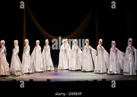 Georgian children dressed with traditional costumes dancing a folklore dance show on stage. Stock Photo