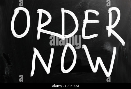 Order now handwritten with white chalk on a blackboard Stock Photo