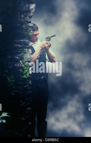 a man in a dark alley, aiming with a gun Stock Photo