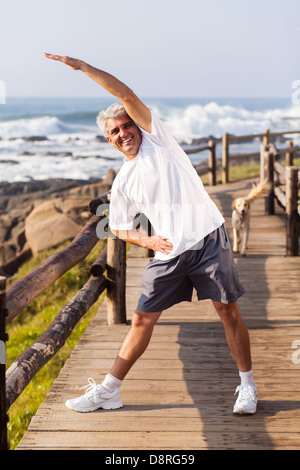 happy senior man doing morning exercise at the beach Stock Photo