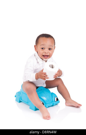 Child on potty play with toilet paper, isolated over white Stock Photo