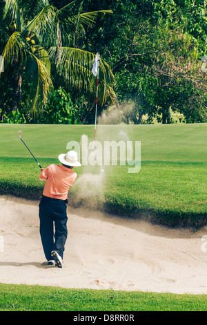 Golfer in sandtrap on 8th hole at Green Valley/St Andrews golf course near Pattaya, Thailand Stock Photo