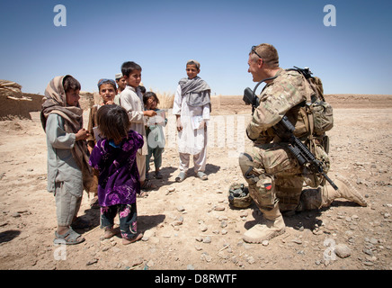 US Army Staff Sgt. Matthew Parsons with the Police Adviser Team Delaram talks with Afghan children May 26, 2013 in Delaram, Helmand province, Afghanistan. Stock Photo