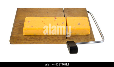 A chunk of cheddar cheese with salami that has been sliced on a cutting board. Stock Photo