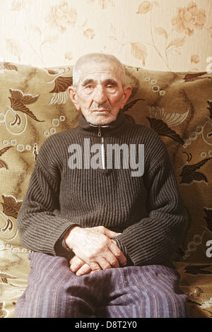 Senior man sitting on sofa Stock Photo