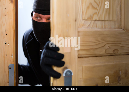 Security - disguised burglar breaking in an apartment or office to steal something Stock Photo