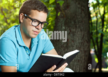 young man reading book in the park Stock Photo