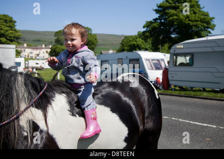 Bainbridge, Richmondshire, North Yorkshire, UK 4th June, 2013.  Lily Corrie, 2 years old on horseback a family member of the travelling community en-route to the Appleby Horse Fair in Cumbria.  The Fair is an annual gathering of Gypsies and Travellers which takes place on the first week in June, and has taken place since the reign of James II, who granted a Royal charter in 1685 allowing a horse fair 'near to the River Eden'. Credit:  Mar Photographics/Alamy Live News Stock Photo
