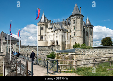 A view of the historic Château de Saumur in the Loire valley, France. Showing tourists crossing the bridge leading to the castle Stock Photo