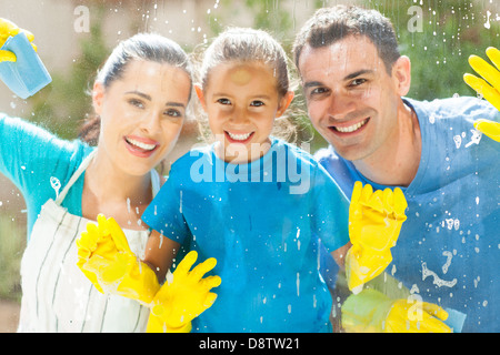 happy young family of three cleaning home window glass together Stock Photo