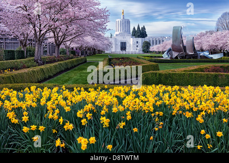 The gold Pioneer Statue stands atop Oregon's State Capitol in Salem overlooking the spring bloom of the Capitol Mall grounds. Stock Photo