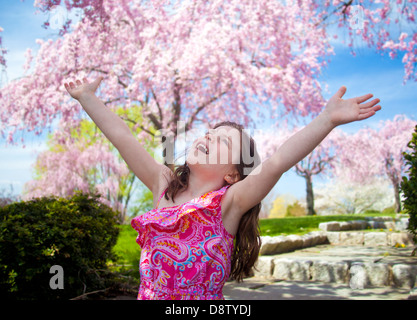 Young girl taking a deep breath enjoying freedom with arms in the air Stock Photo