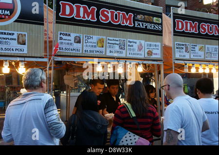 People buying Dim Sum snacks at a street food stall at the night market in Chinatown, British Columbia, Canada Stock Photo